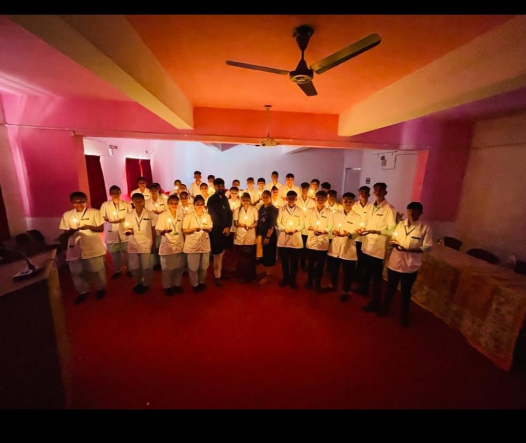 Nursing students holding lit lamps during their pledge ceremony