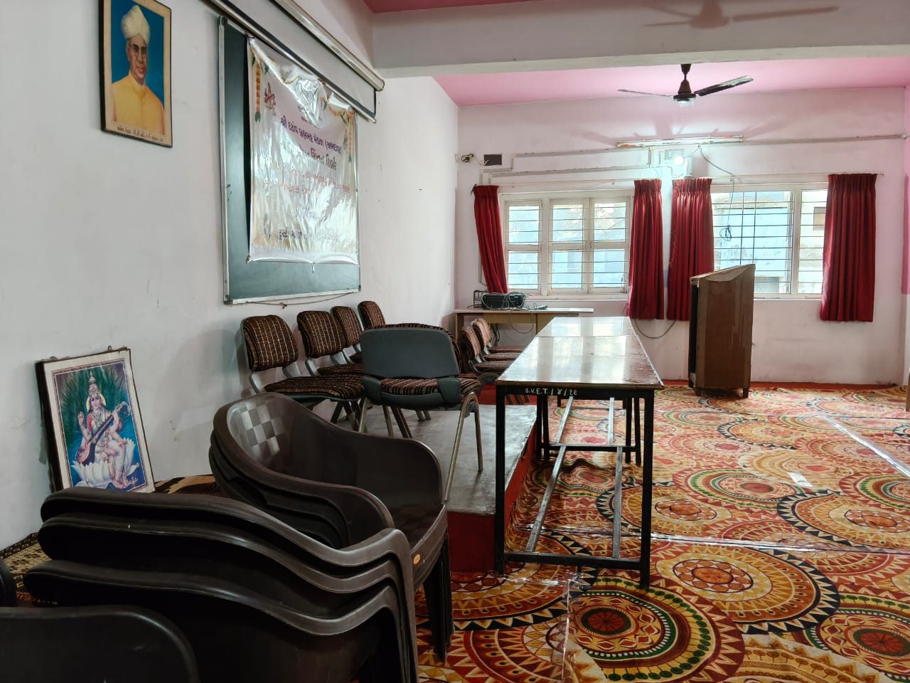 Seminar hall preparation area with trustee portraits on the wall