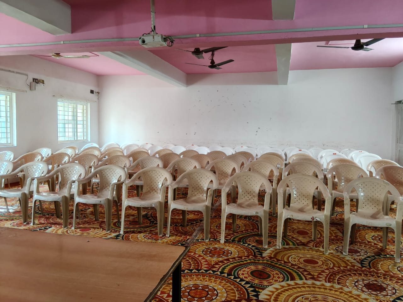 Seminar hall set up with rows of chairs facing the podium